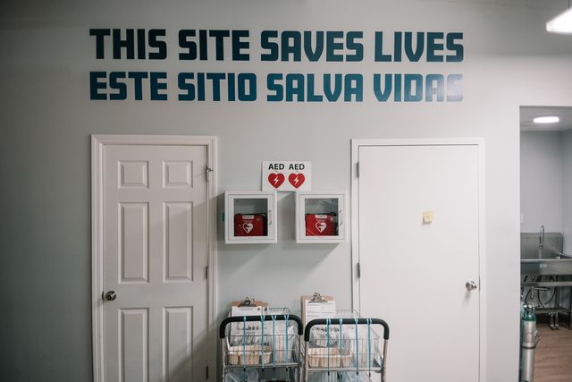A sign inside the room where people use drugs at the OnPoint NYC overdose prevention center in Harlem reads, “This site saves lives,” in English and Spanish.